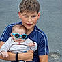 child, baby, sunglasses, blue, holding, casual, outdoor, pavement, cute, fashion, protective, person, portrait, young, smiling, clothing, bracelet, expression, funny, toddler
