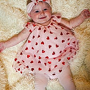 Autumn-Rose is registered to the contest to win money with this photo: baby, infant, pink_dress, headband, bow, red_hearts, leggings, white_shoes, smiling, cute, fluffy_rug, soft_texture, lying_down, child, adorable, portrait, happy, indoors, clothing, baby_fashion