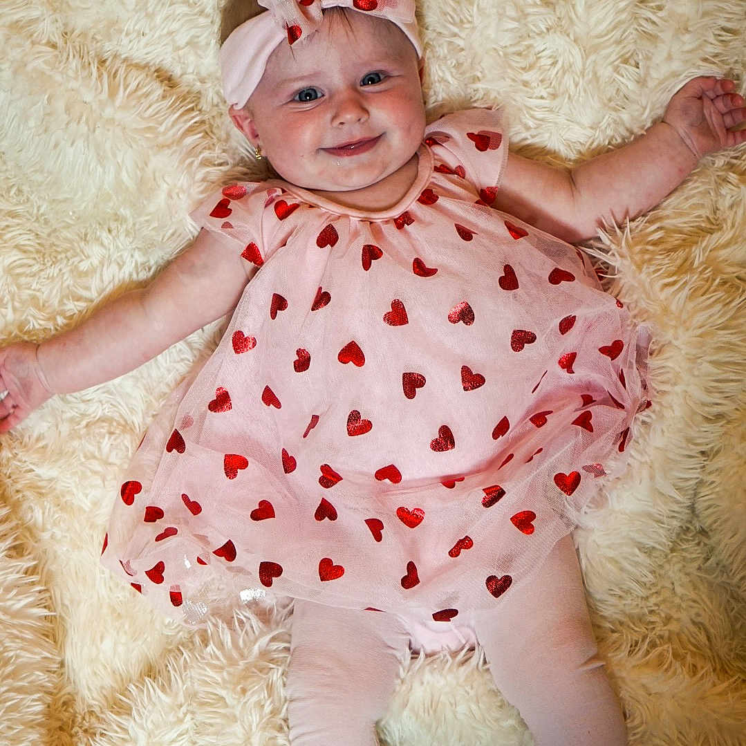 Autumn-Rose is registered to the contest to win money with this photo: adorable, baby, baby_fashion, bow, child, clothing, cute, fluffy_rug, happy, headband, indoors, infant, leggings, lying_down, pink_dress, portrait, red_hearts, smiling, soft_texture, white_shoes