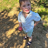 Noé a rejoint le concours — aidez-le/la à gagner de superbes lots ! boy, casual_clothing, child, daylight, earth, fruit, grass, happy, nature, outdoor, person, portrait, red_fruit, sandals, shadow, shorts, smiling, striped_shirt, summer, sunlight