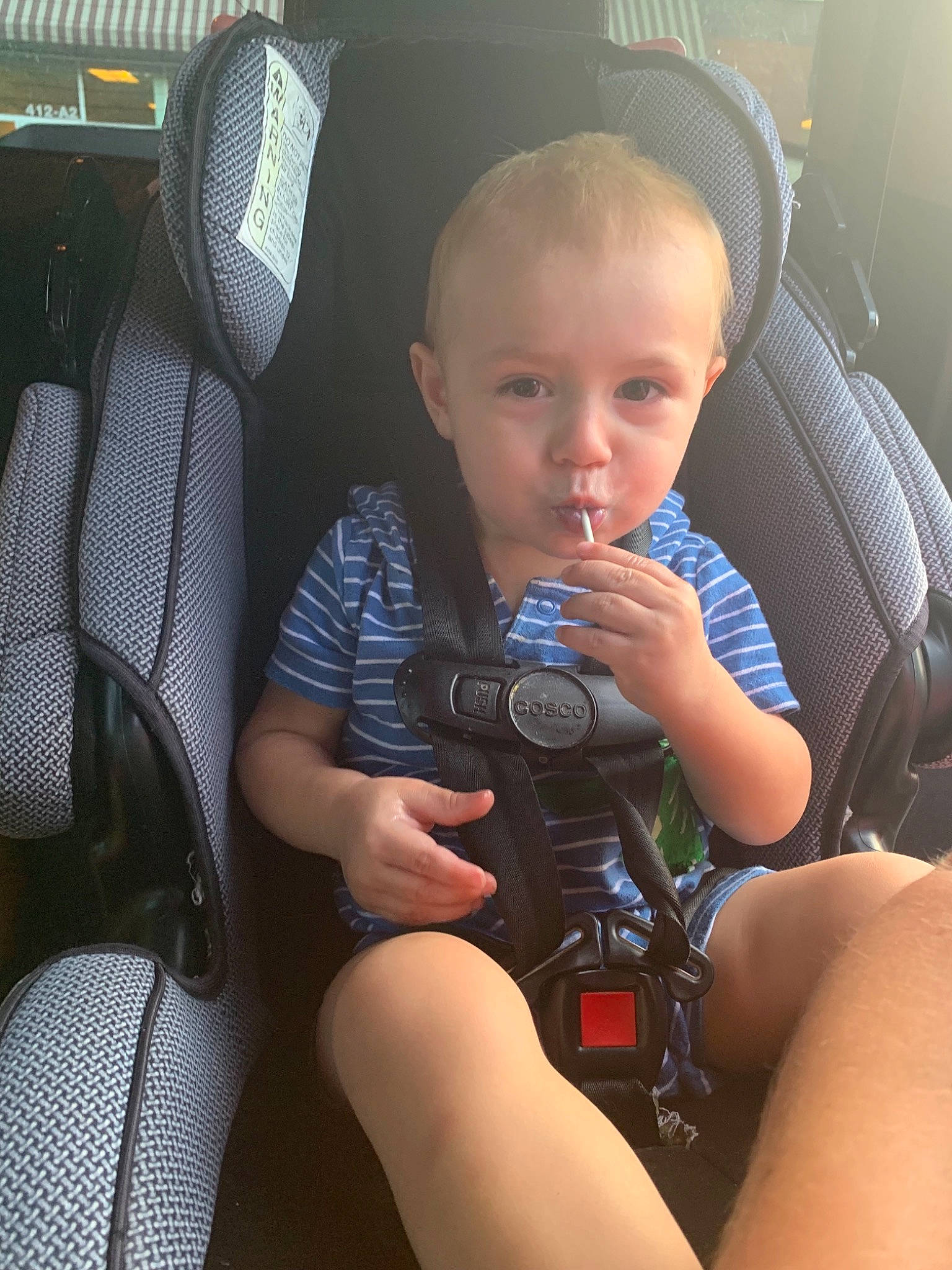 Gavin is registered to the contest to win money with this photo: camera, cameras_optics, car_seat, child, finger, leg, person, photography, sitting, thigh, toddler