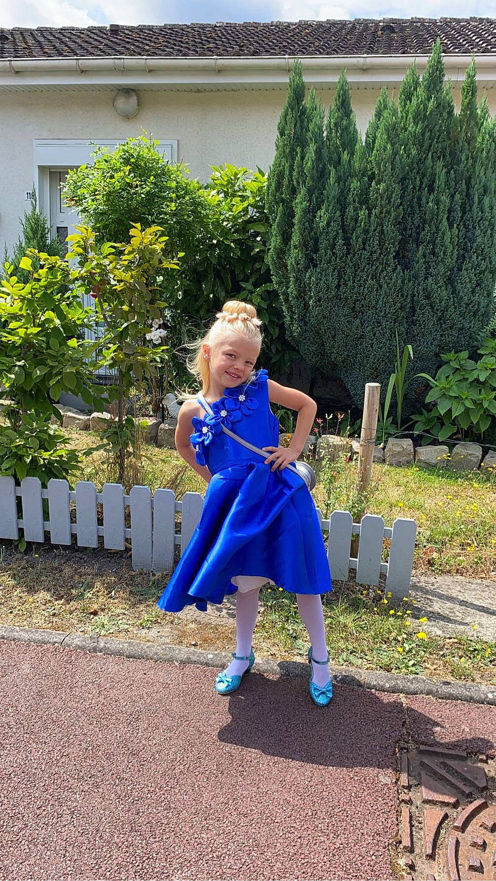 Julia participe au concours pour gagner de l'argent avec cette photo : costume, denim, dress, electric_blue, fence, formal_wear, fun, garden, grass, joy, leisure, magenta, pattern, people_in_nature, person, plant, recreation, shrub, sitting, toddler