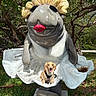 Sunny is registered to the contest to win money with this photo: dog, golden_retriever, puppy, pet, sitting, smiling, tongue_out, black_harness, statue, sculpture, giant_figure, red_lips, shell_hair, outdoor, garden, trees, grass, sunlight, portrait, humorous