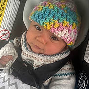 Kai joined the competition — help win amazing prizes! baby, child, car_seat, knitted_hat, colorful, sweater, blanket, safety, seatbelt, infant, cute, portrait, indoors, warm_clothing, young_child, closeup, person, face, headwear, comfort