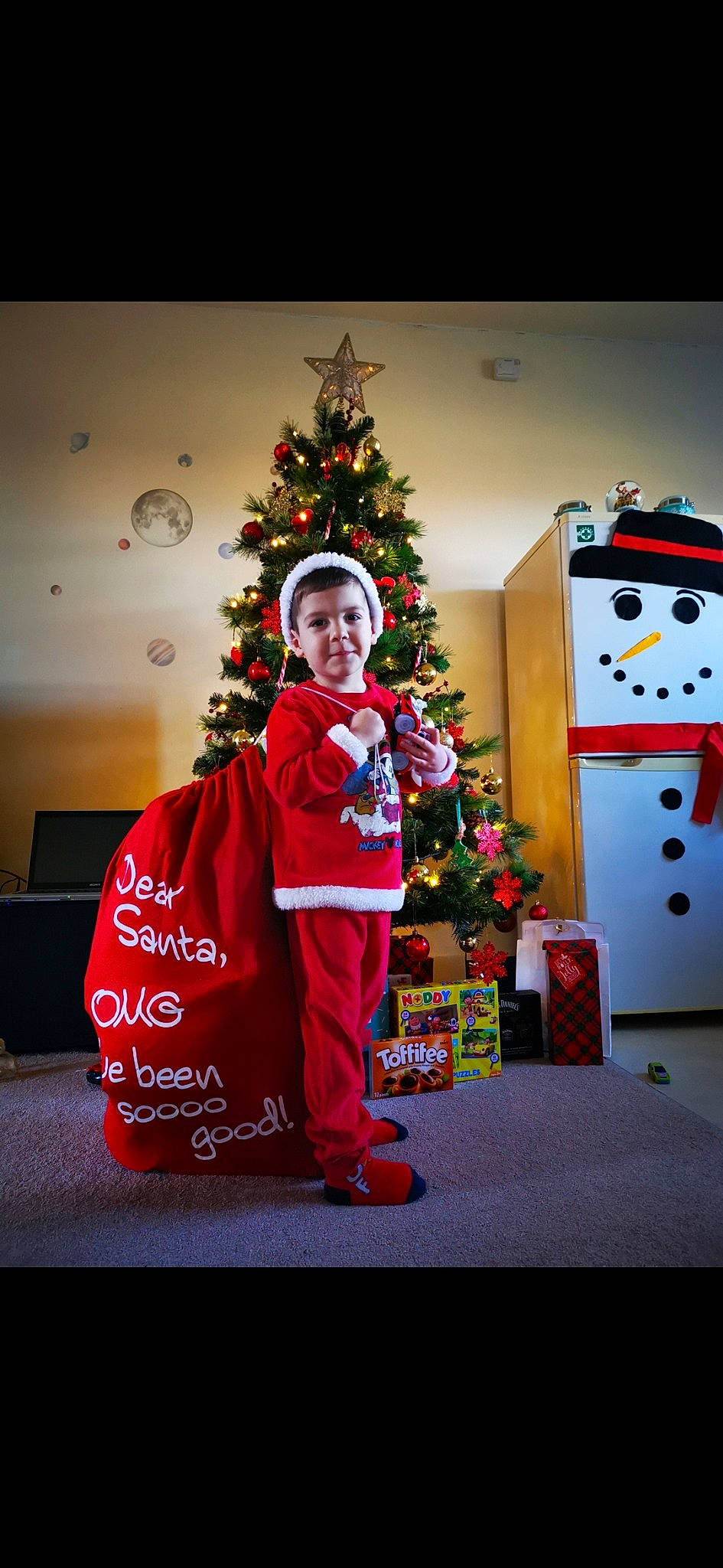 Alexandru joined the competition — help win amazing prizes! carmine, christmas, christmas_decoration, christmas_eve, christmas_lights, christmas_ornament, christmas_tree, conifer, costume_accessory, costume_hat, event, fictional_character, fir, holiday, holiday_ornament, interior_design, ornament, person, pine_family, red