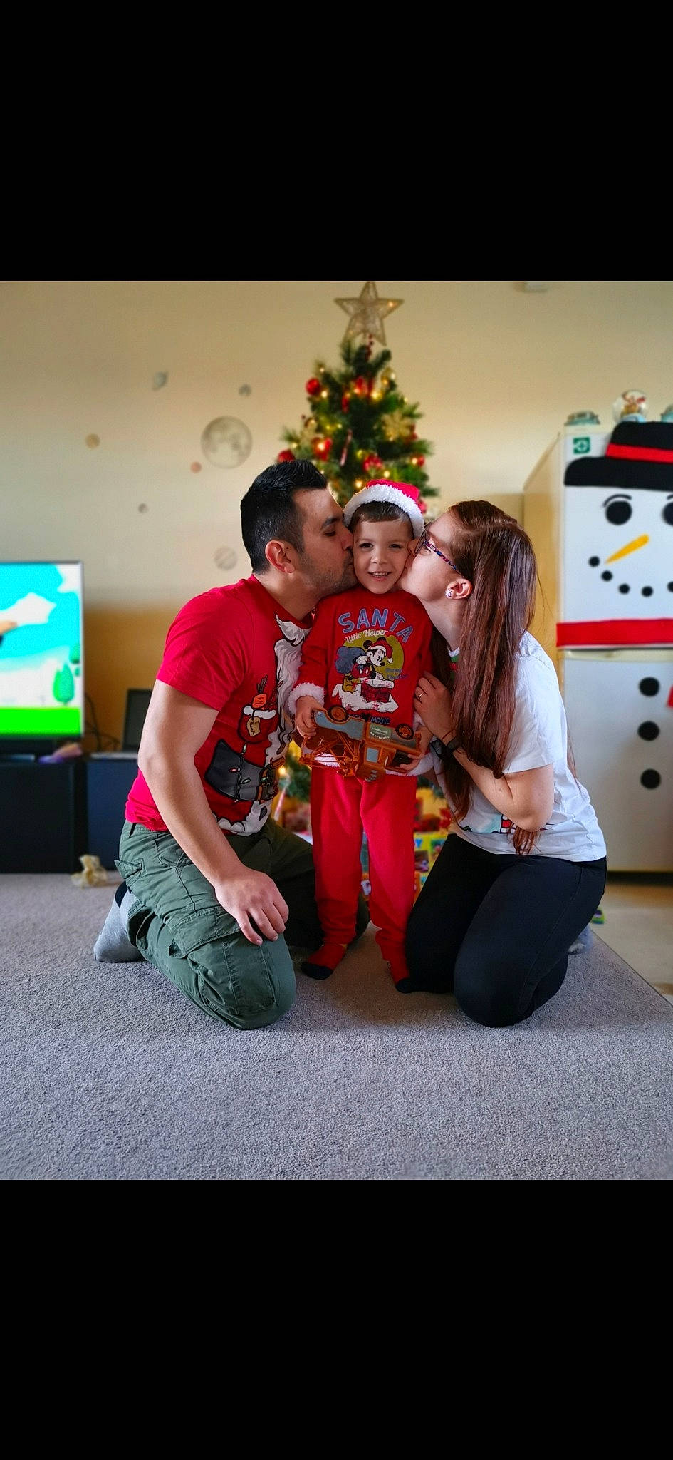 Alexandru is registered to the contest to win money with this photo: christmas, christmas_decoration, christmas_eve, christmas_lights, christmas_ornament, christmas_tree, comfort, display_device, event, holiday, holiday_ornament, interior_design, joy, lap, ornament, person, room, sitting, television, television_set