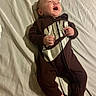 Raeshayn is registered to the contest to win money with this photo: baby, infant, child, onesie, nike, clothing, red_socks, bed, sheet, lying_down, happy, smiling, face, hands, feet, sleepwear, indoors, person, cute, cozy