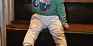 Wyatt is registered to the contest to win money with this photo: toddler, child, smiling, stairs, wooden_stairs, green_sweatshirt, monster_truck, casual_clothing, indoor, handrail, holding, happy, young_child, footwear, brown_shoes, carpet, portrait, sitting, railing, person