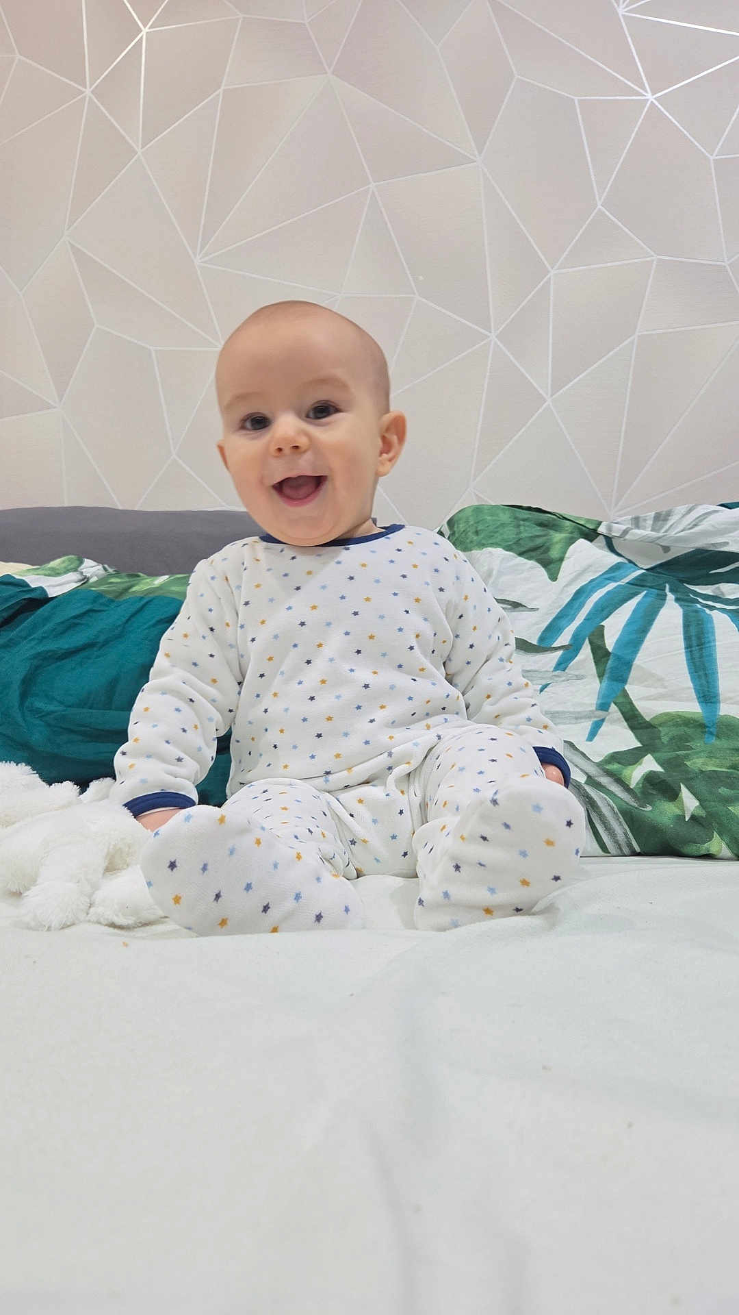 Mylan a rejoint le concours — aidez-le/la à gagner de superbes lots ! baby, bed, blanket, child, cozy, cute, face, happy, head, homedecor, indoor, infant, pajamas, patterned_clothing, person, pillow, sitting, sleepwear, smiling, young_child