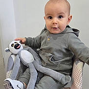 Mylan participe au concours pour gagner de l'argent avec cette photo : baby, carpet, chair, child, cute, grey_clothing, hoodie, indoor, monkey, nike, pants, patterned_fabric, person, portrait, smiling, sneakers, stuffed_toy, toy, white_shoes, wooden_legs