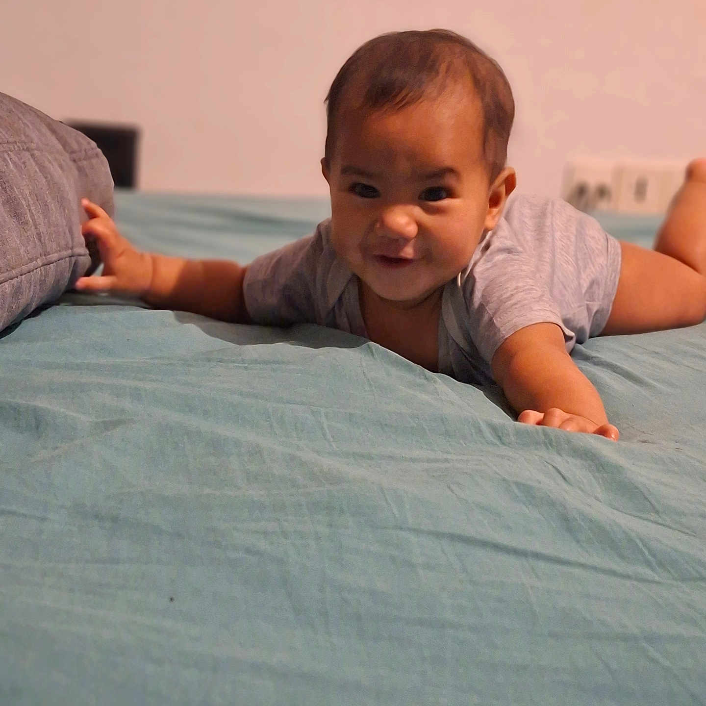 Heinui participe au concours pour gagner de l'argent avec cette photo : arm, baby, bed, bedding, cute, face, hair, hand, home, indoor, infant, onesie, pillow, playful, plug_socket, portrait, relaxed, smile, tummy_time, young_child