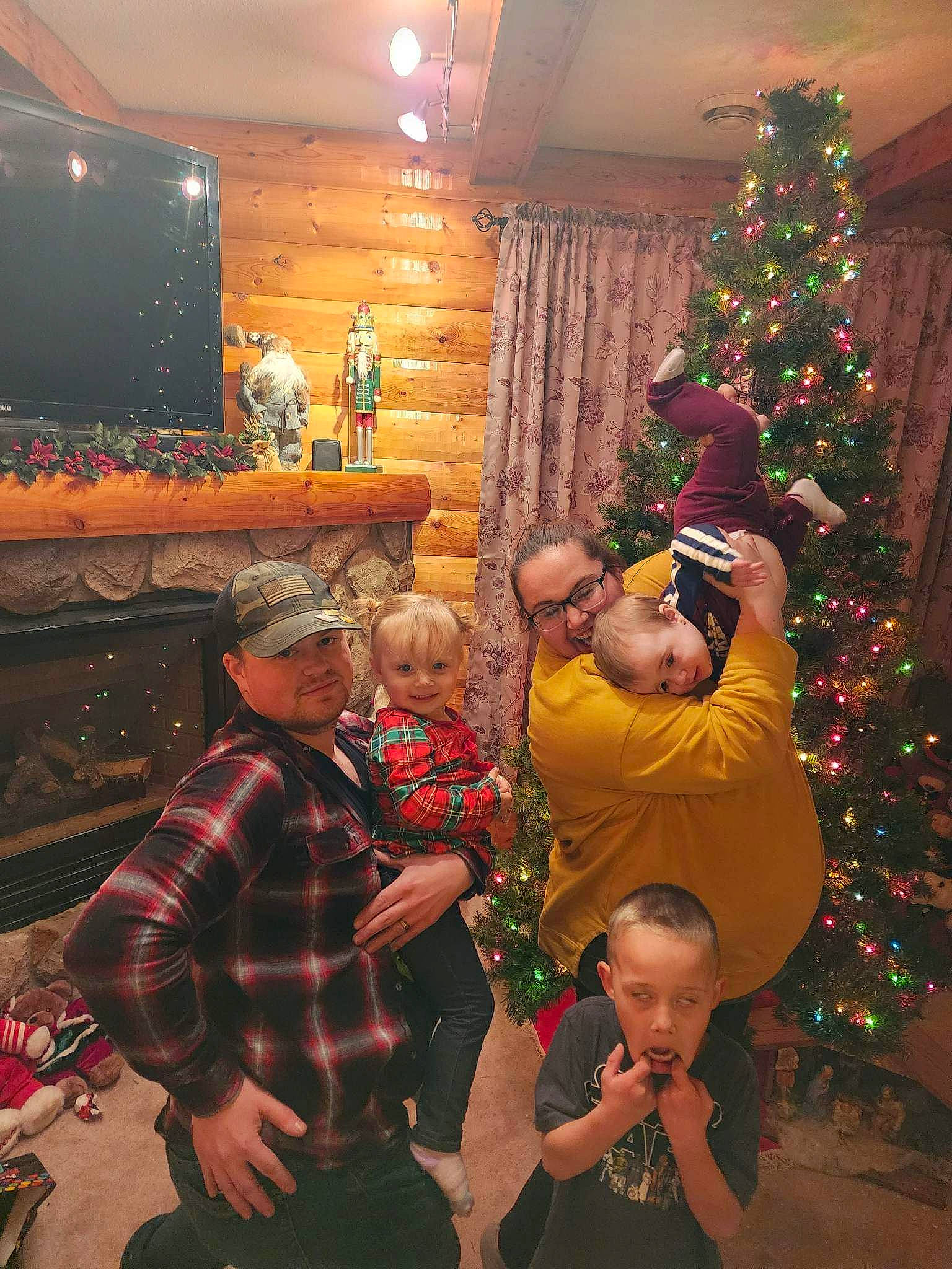 Evelyn is registered to the contest to win money with this photo: christmas, christmas_decoration, christmas_eve, christmas_ornament, christmas_tree, event, fun, happy, headwear, holiday, holiday_ornament, joy, lap, ornament, person, plant, red, room, snapshot, standing