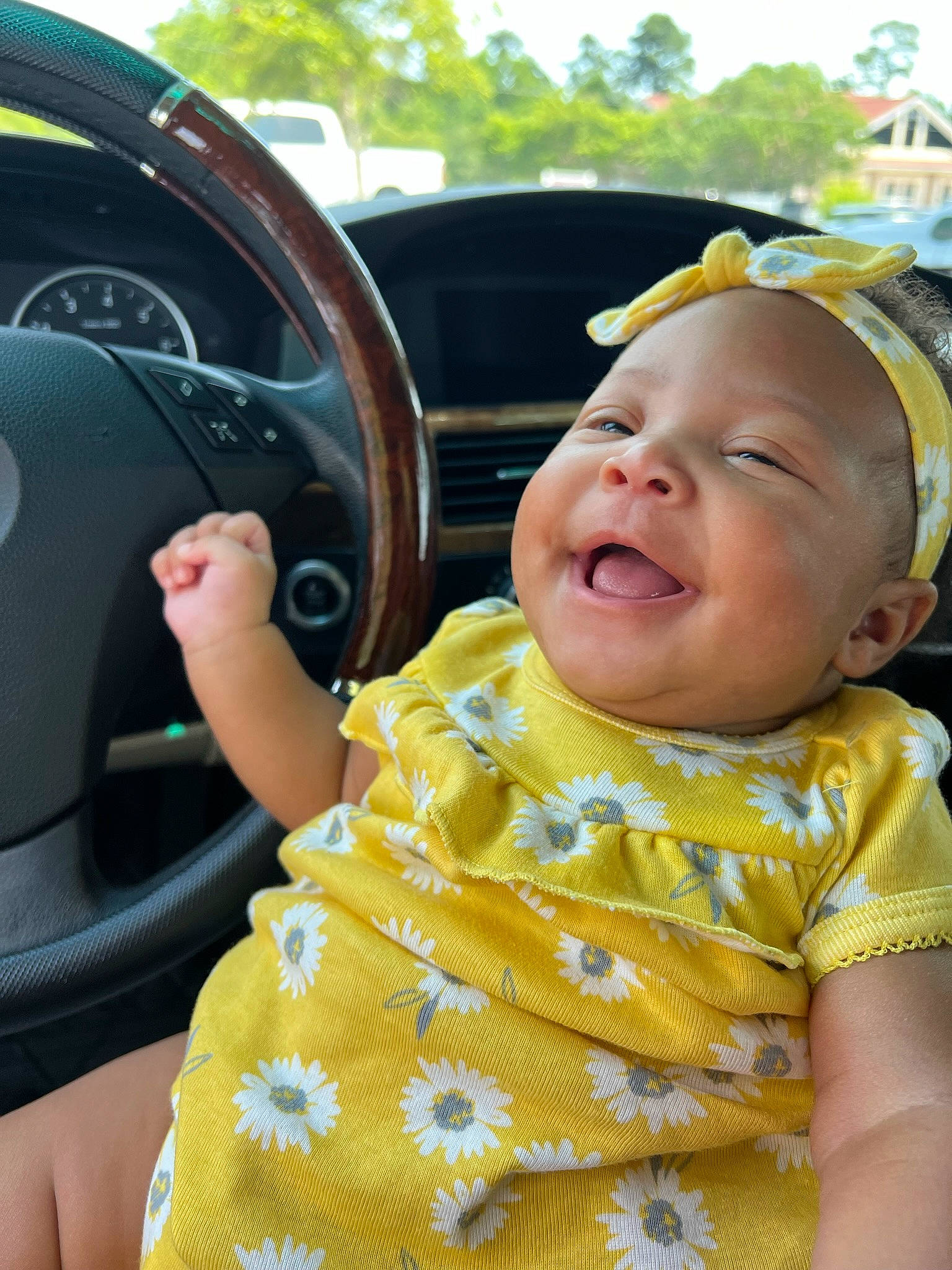 Kali is registered to the contest to win money with this photo: automotive_design, automotive_exterior, baby, baby_laughing, baby_toddler_clothing, car, dress, fun, happy, hat, motor_vehicle, person, product, skin, smile, steering_part, steering_wheel, toddler, vehicle_door, wheel