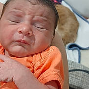 Rhylee is registered to the contest to win money with this photo: newborn, baby, infant, person, face, arm, orange_shirt, hair, scrunched_face, sleepy, blanket, pet, cat, indoor, closeup, skin, hand, resting, cute, sleep