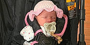 Rhylee is registered to the contest to win money with this photo: baby, sleeping, pacifier, hat, onesie, stroller, baby_clothing, infant, child, polka_dot, pink, black, strap, wood_floor, indoor, cute, peaceful, newborn, baby_accessory, headwear