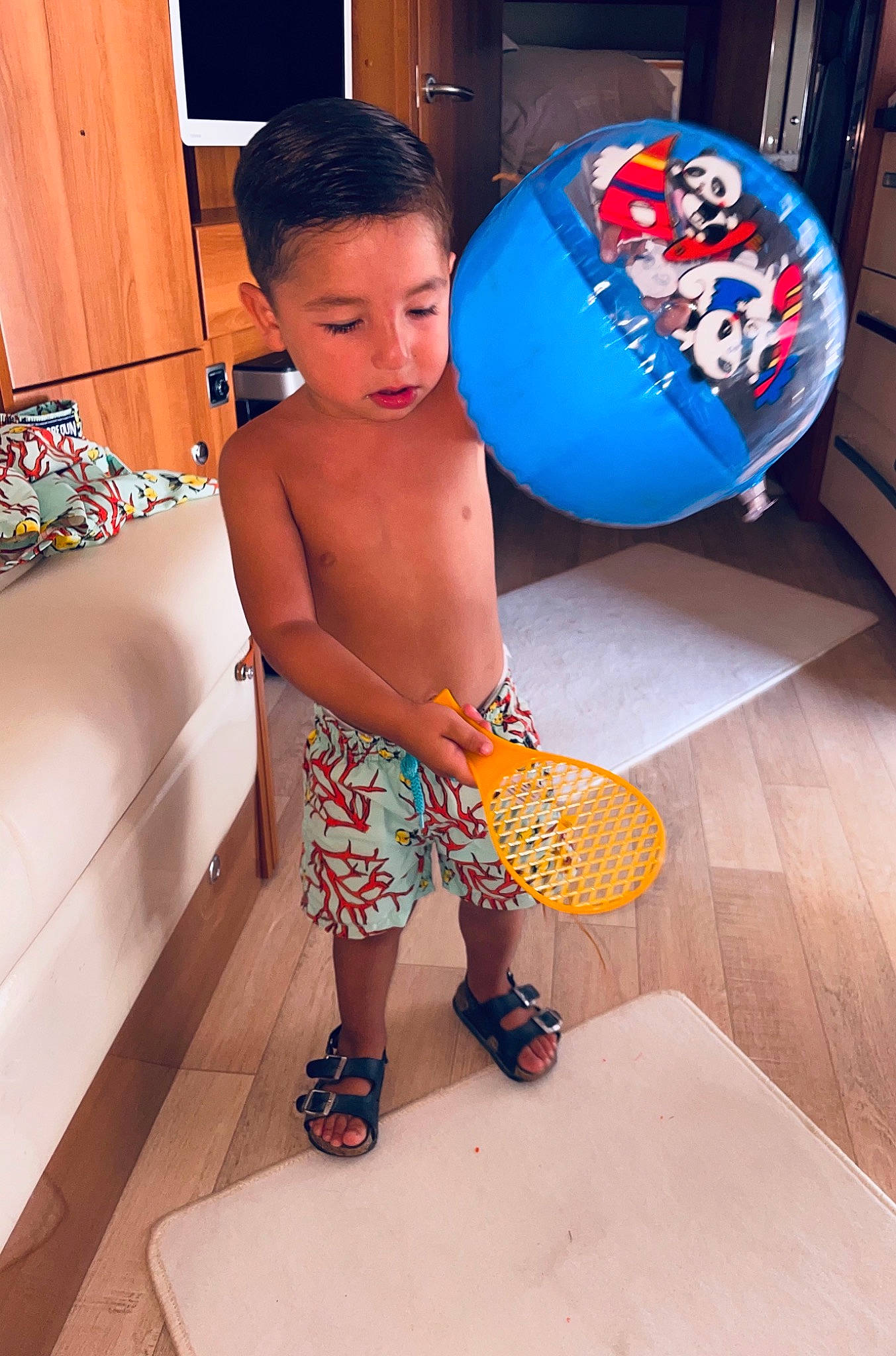 Raphaël a rejoint le concours — aidez-le/la à gagner de superbes lots ! board_short, calf, child, electric_blue, flip_flops, flooring, fun, human_leg, knee, leg, leisure, person, play, room, sandal, shorts, slipper, t_shirt, thigh, toddler