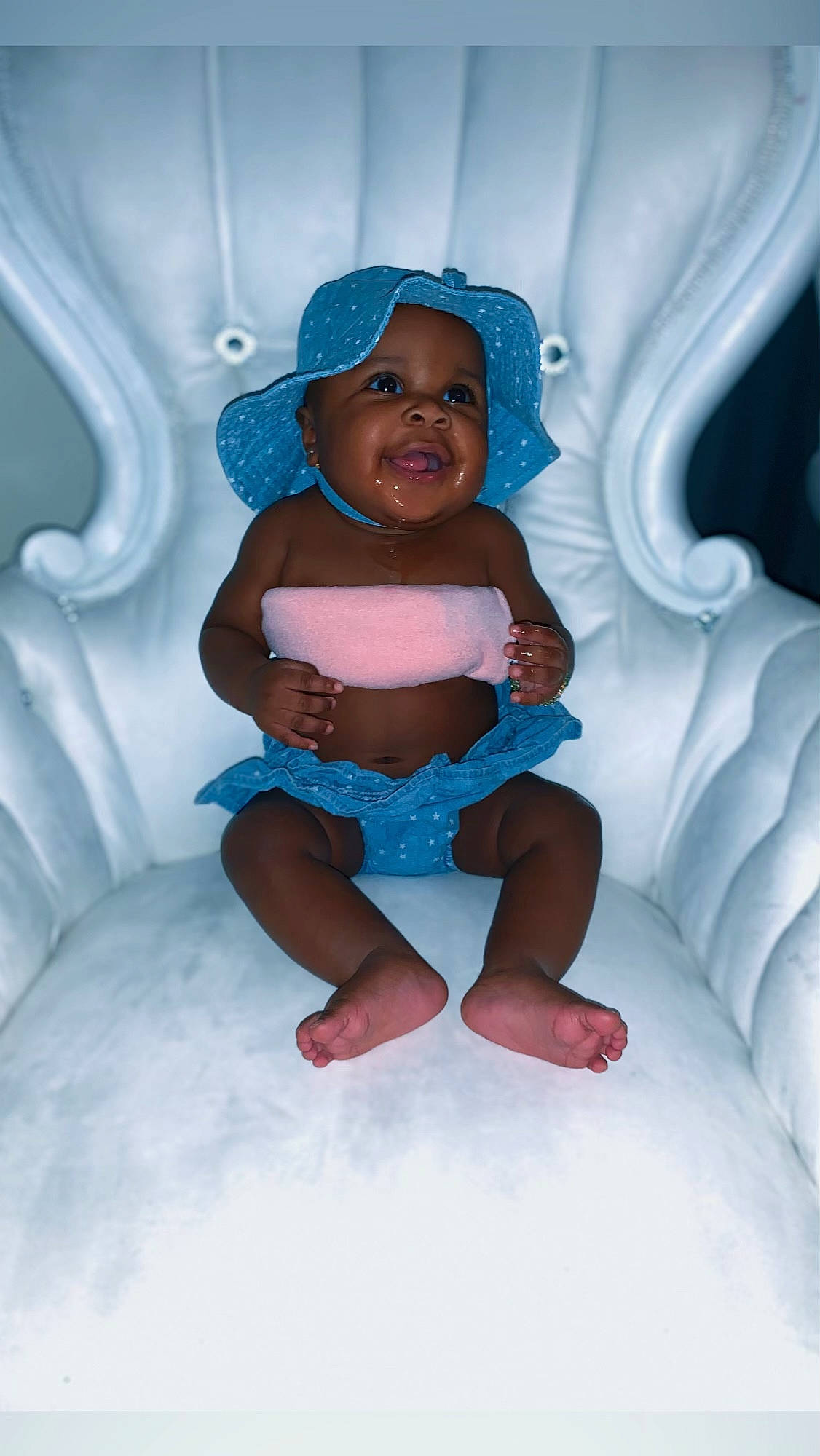 Anavi is registered to the contest to win money with this photo: aqua, arm, baby, baby_toddler_clothing, comfort, electric_blue, finger, flash_photography, fun, happy, hat, headwear, human_leg, knee, mouth, person, pink, purple, skin, textile