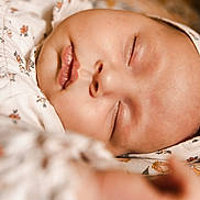 Victoire participe au concours pour gagner de l'argent avec cette photo : baby, sleeping, close_up, headband, floral_pattern, infant, peaceful, soft_lighting, skin, face, mouth, nose, eyelids, clothing, fabric, texture, cute, rest, child, portrait