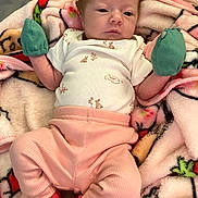 Evelyn is registered to the contest to win money with this photo: baby, infant, blanket, mittens, clothing, pink_pants, soft_texture, lying_down, close_up, cute, young_child, sleepwear, warm, indoor, portrait, newborn, person, face, head, resting