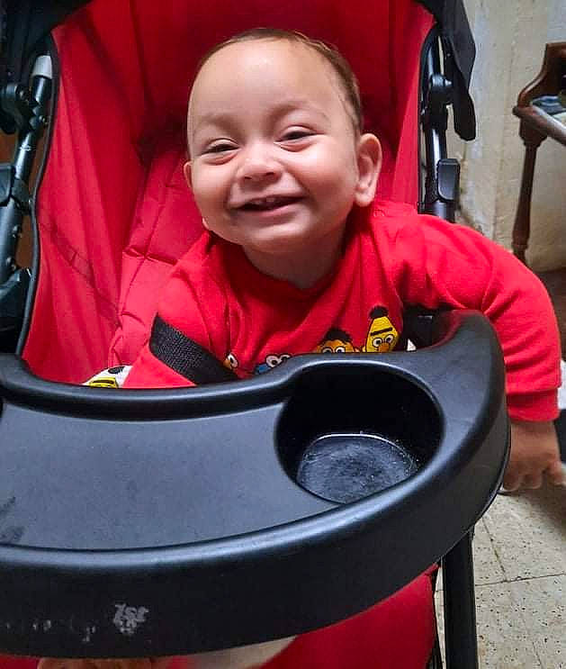 Liam a rejoint le concours — aidez-le/la à gagner de superbes lots ! auto_part, automotive_wheel_system, baby, baby_carriage, baby_products, baby_safety, baby_toddler_clothing, car_seat, carmine, child, comfort, fun, happy, joy, magenta, mammal, person, personal_protective_equipment, red, sitting