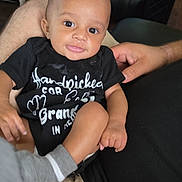 Tayvion is registered to the contest to win money with this photo: baby, child, infant, smiling, portrait, sitting, black_outfit, onesie, adult, hands, car_interior, vehicle, plaid_fabric, laundry_basket, closeup, face, eyes, happy, family, indoor