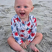 Rose joined the competition — help win amazing prizes! baby, child, beach, sand, smile, happy, headband, bow, swimsuit, floral_pattern, sitting, barefoot, outdoor, sunlight, cute, playful, portrait, person, infant, summer