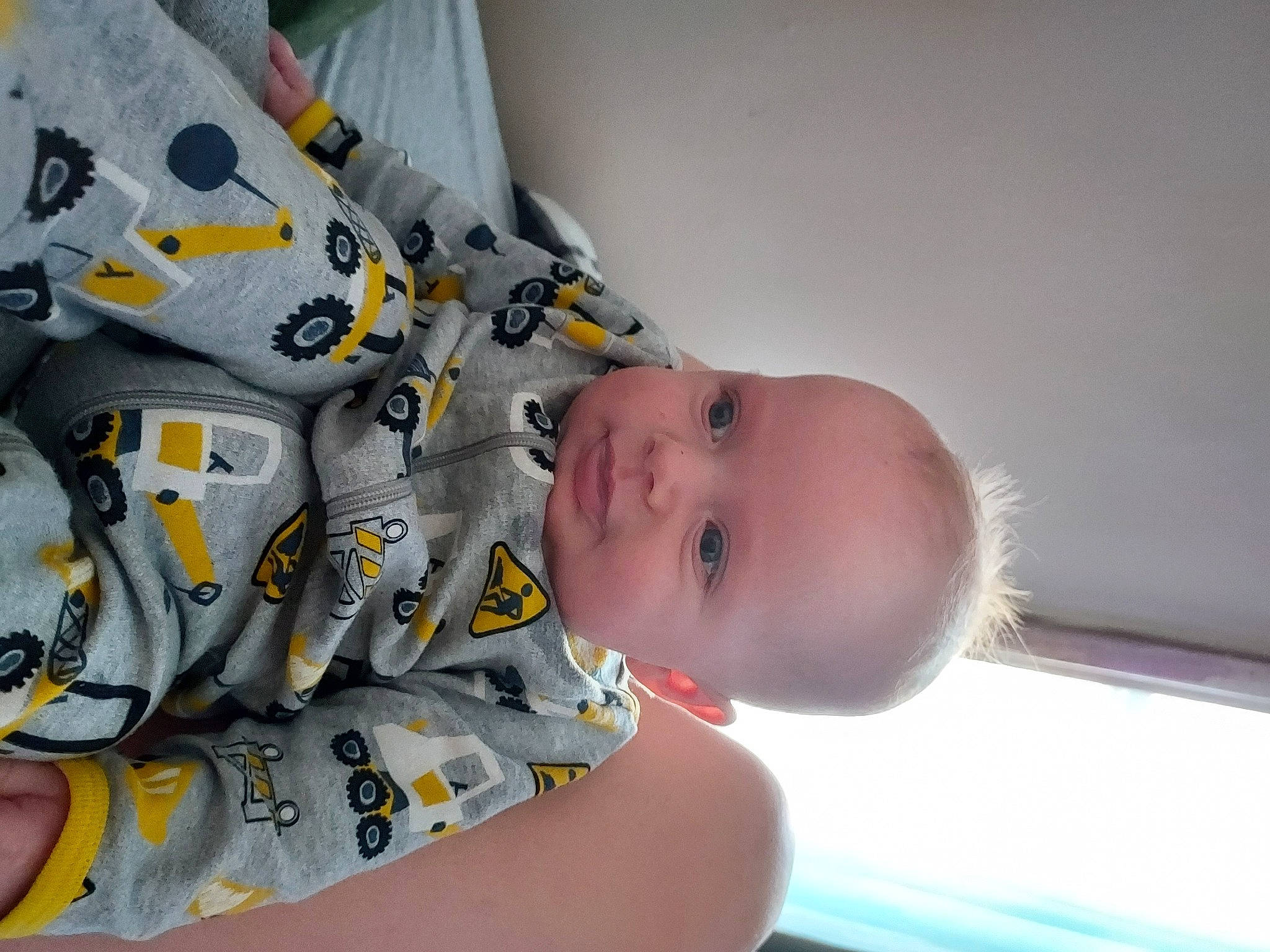 Mark is registered to the contest to win money with this photo: baby, baby_products, baby_toddler_clothing, carmine, cheek, chest, child, comfort, eye, fun, hand, happy, head, human_body, pattern, person, room, sitting, sleeve, thumb