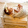 newborn, baby, sleeping, lace, bow, headband, wooden_bed, cushion, blanket, cozy, soft, cute, infant, wrapped, portrait, resting, indoors, peaceful, toddler, child