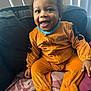 toddler, child, costume, scooby_doo, orange, smile, happy, couch, blanket, indoor, curtains, clothing, person, furniture, cute, portrait, seated, cozy, hand, face