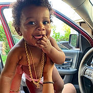 Amun-Ra joined the competition — help win amazing prizes! toddler, child, curly_hair, gold_chain, inside_car, car_door, hand, smiling, happy, skin, person, playful, fingers, mouth, jewelry, bracelet, seat, window, daylight, vehicle