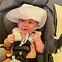 baby, car_seat, white_hat, bottle, infant, happy, smiling, hands, seatbelt, indoor, floor, child, cute, skin, headwear, young, person, feeding, safety, expression