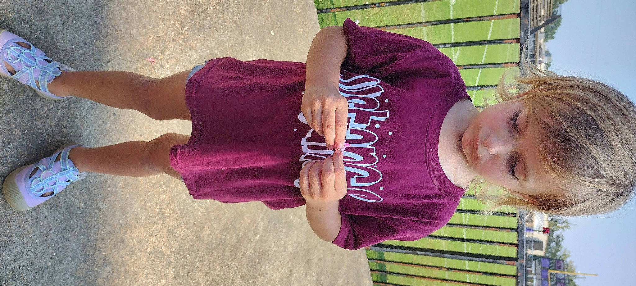 Coraline is registered to the contest to win money with this photo: baby_toddler_clothing, elbow, finger, fun, grass, hand, happy, hat, human_leg, knee, leisure, magenta, person, pink, purple, recreation, sleeve, t_shirt, thigh, toddler