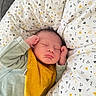 Sandro a rejoint le concours — aidez-le/la à gagner de superbes lots ! baby, newborn, sleeping, pillow, pattern, yellow_bib, green_outfit, infant, peaceful, cozy, face, hands, cute, soft_fabric, resting, child, indoors, portrait, sleep, blanket