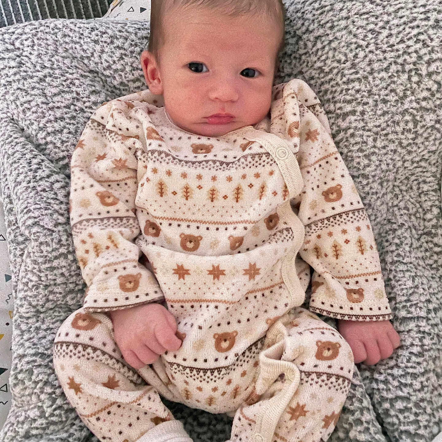 Sandro participe au concours pour gagner de l'argent avec cette photo : baby, infant, blanket, onesie, clothing, pattern, bear, soft_texture, sleepwear, cute, newborn, person, portrait, lying_down, white_socks, cozy, indoor, warm, small_hands, curious