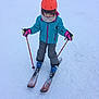 child, skiing, snow, winter, helmet, ski_poles, jacket, gloves, ski_boots, ski_resort, snowy, outdoor, young_child, sports, recreation, cold_weather, scarf, ski_pants, beginners, activity