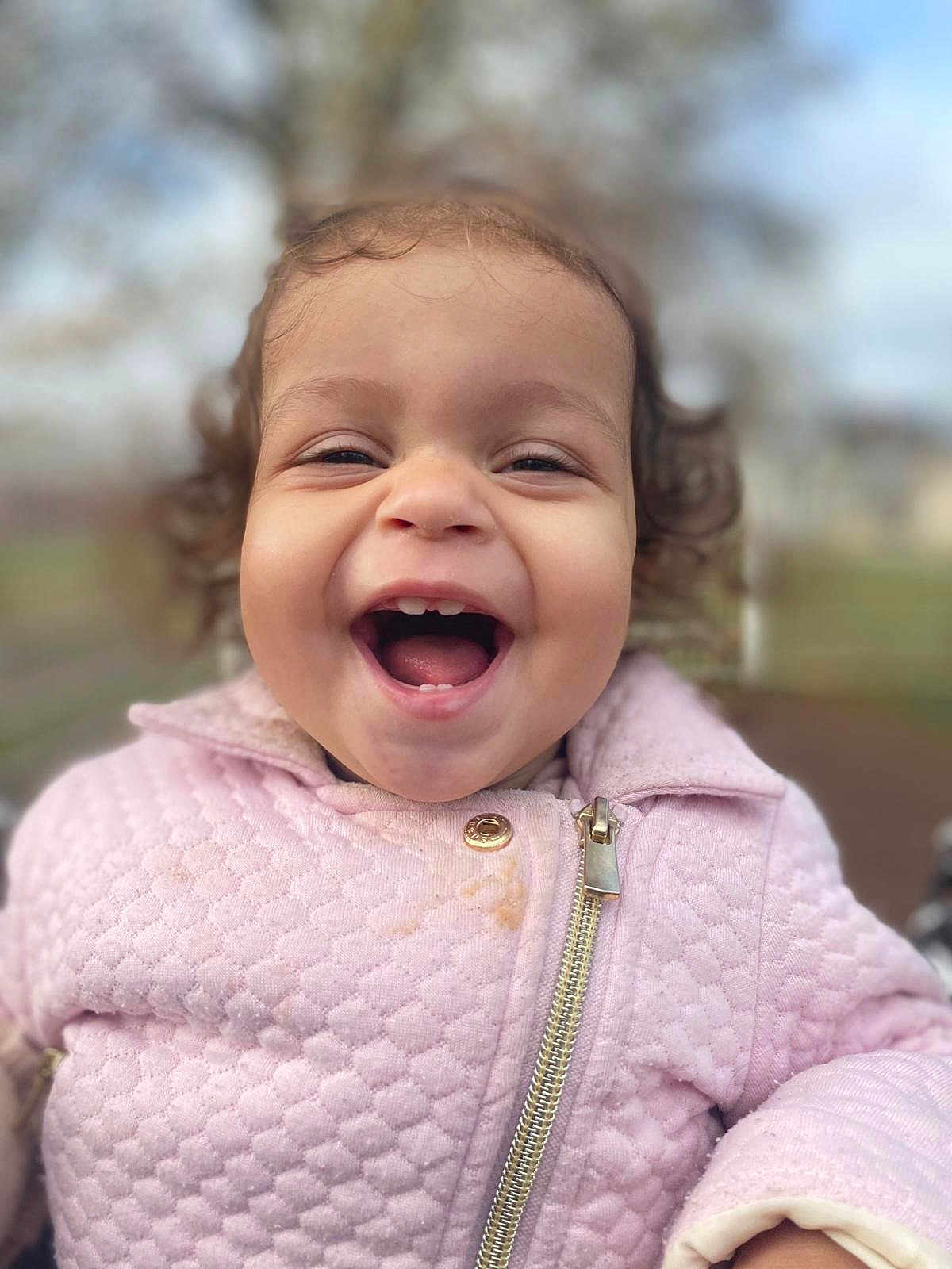 Nélya participe au concours pour gagner de l'argent avec cette photo : child, closeup, curly_hair, cute, expression, face, fun, happy, jacket, joy, laughing, outdoor, person, pink_clothing, portrait, smiling, toddler, warm_clothing, young_child, zipper