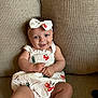 Isabel joined the competition — help win amazing prizes! baby, child, smiling, sitting, dress, headband, bow, cherry_pattern, couch, furniture, happy, cute, infant, portrait, indoor, skin, face, person, clothing, young
