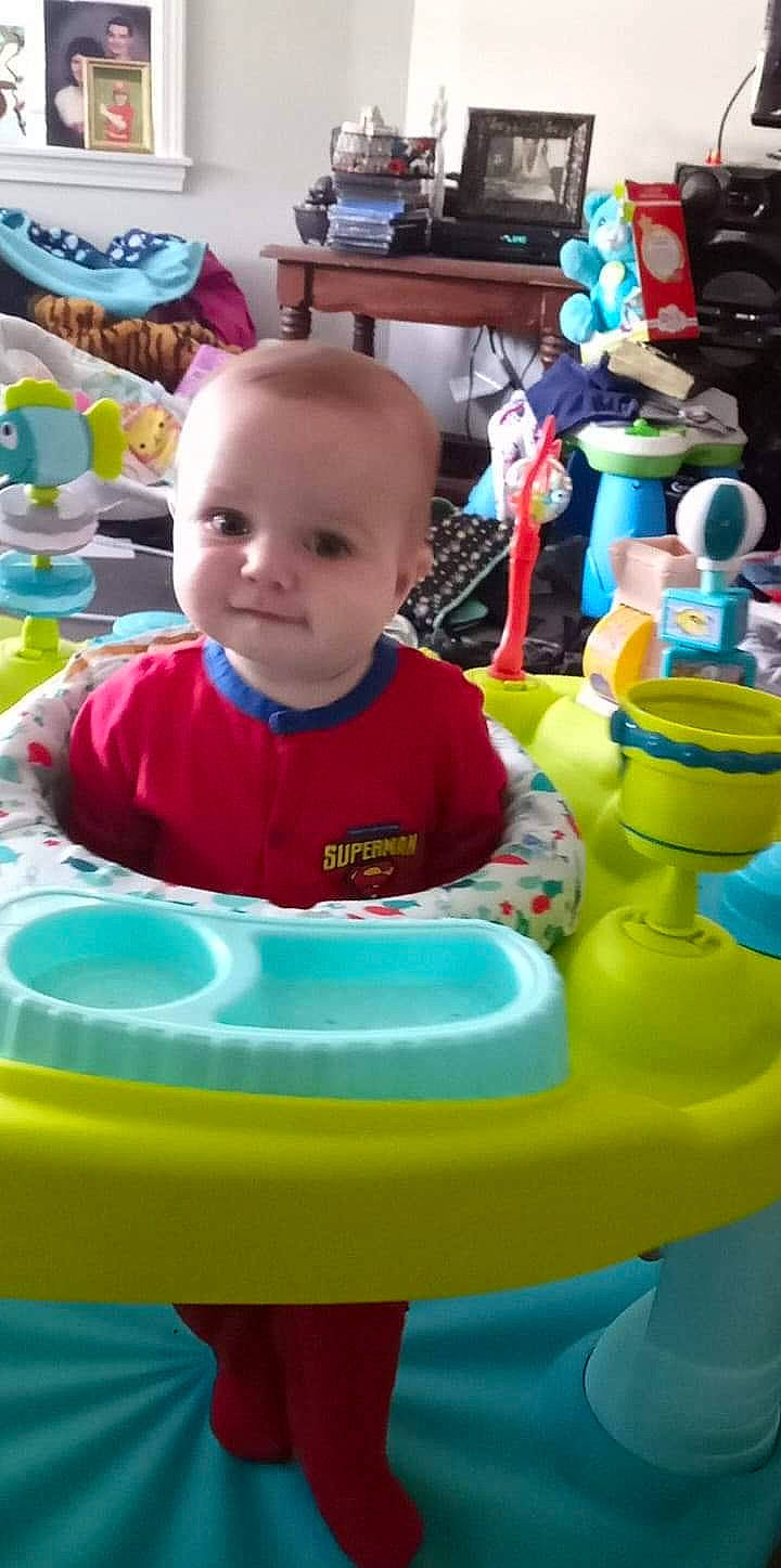 Jordan is registered to the contest to win money with this photo: baby, baby_playing_with_toys, baby_products, baby_toddler_clothing, blue, chair, child, event, facial_expression, fun, happy, leisure, person, play, recreation, sitting, smile, t_shirt, toddler, toy