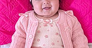 Maria is registered to the contest to win money with this photo: baby, infant, child, portrait, smiling, sitting, pink, headband, flower, clothing, sweater, dress, bow, quilt, blanket, indoors, close_up, cute, fashion, happy