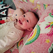 Ava is registered to the contest to win money with this photo: adorable, baby, cheeks, closeup, cute, doll, happy, infant, lying_down, nursery, onesie, pacifier, pink_blanket, playmat, portrait, rainbow, smiling_baby, soft_texture, stuffed_toy, unicorn_pattern