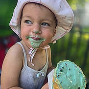 Aurelia is registered to the contest to win money with this photo: child, cone, cute, face, food, fun, green_ice_cream, happy, hat, ice_cream, messy, mint_chocolate_chip, outdoor, pink_hat, playful, portrait, smile, summer, tank_top, toddler