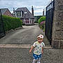 Aurelia is registered to the contest to win money with this photo: casual_clothing, child, cloudy_sky, driveway, flower, flowers, girl, headband, hedge, house, outdoor, person, shirt, shoes, sidewalk, skirt, smiling, stone_house, toddler, young_child