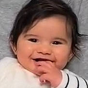 Naho participe au concours pour gagner de l'argent avec cette photo : baby, infant, toddler, smile, happy, chubby_cheeks, dark_hair, eyes, hand, fingers, mouth, teeth, white_clothing, striped_sleeve, portrait, close_up, indoor, soft_lighting, background, adorable