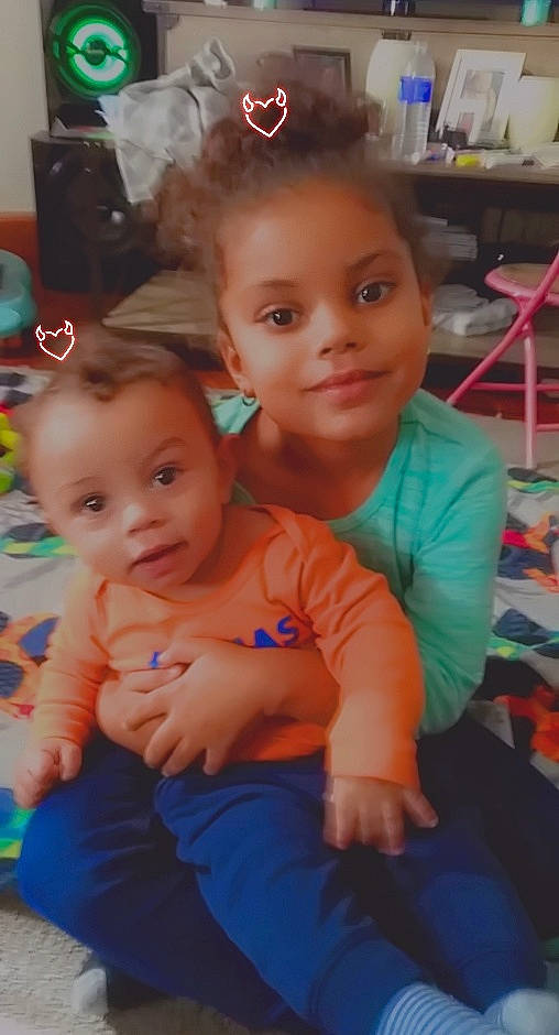 Giovani is registered to the contest to win money with this photo: abdomen, baby, baby_toddler_clothing, cheek, child, ear, eye, face, finger, forehead, hand, head, iris, joy, mouth, nose, person, shelf, shelving, sitting