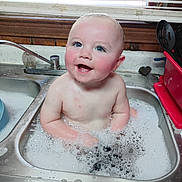 Kayden joined the competition — help win amazing prizes! baby, child, sink, bath, bubbles, water, kitchen, faucet, soapy, happy, smiling, face, arms, countertop, window, blinds, utensils, red_container, foam, cleaning