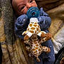baby, pacifier, plush_toy, giraffe, blanket, blue_clothing, infant, cute, soft_texture, cozy, sleepwear, child, newborn, resting, comfort, warm_colors, indoor, portrait, small_hands, cute_expression