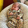 baby, newborn, sleeping, cushion, pillow, floral, onesie, indoors, cozy, peaceful, infant, soft, patterned, cute, child, person, resting, comfort, blanket, home