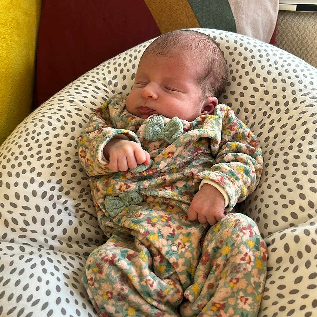 Juliette a rejoint le concours — aidez-le/la à gagner de superbes lots ! baby, blanket, child, comfort, cozy, cushion, cute, floral, home, indoors, infant, newborn, onesie, patterned, peaceful, person, pillow, resting, sleeping, soft