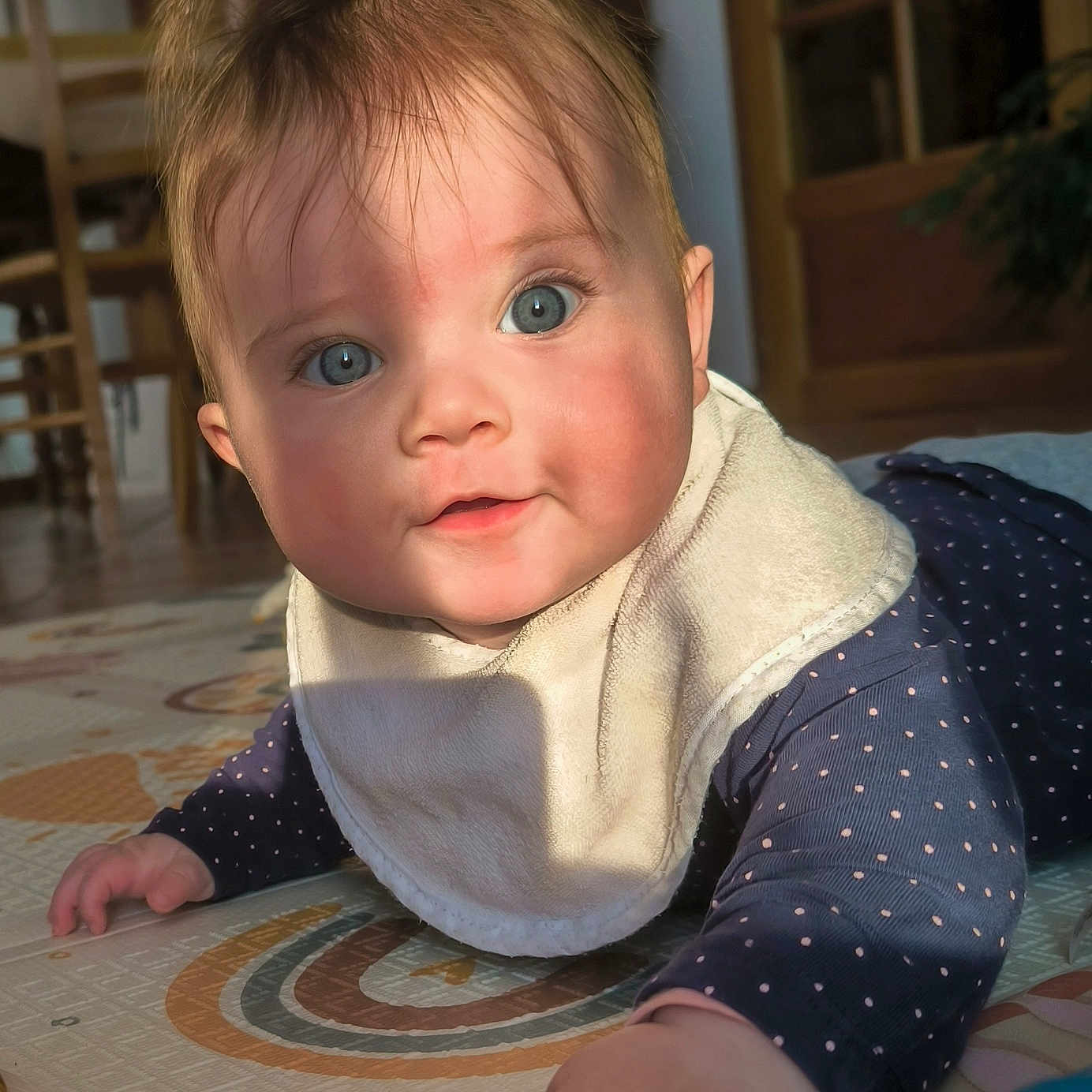 Alix a rejoint le concours — aidez-le/la à gagner de superbes lots ! baby, bib, blue_eyes, crawling, cute, door, face, furniture, hand, indoor, infant, long_sleeves, play_mat, polka_dots, portrait, shadow, sunlight, toy, wide_eyes, wooden_chair