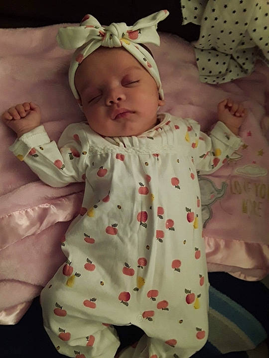 Layla is registered to the contest to win money with this photo: arm, baby, baby_sleeping, baby_toddler_clothing, cheek, chin, dress, eye, face, hand, head, human_body, iris, lip, mouth, nose, person, pink, skin, sleeve